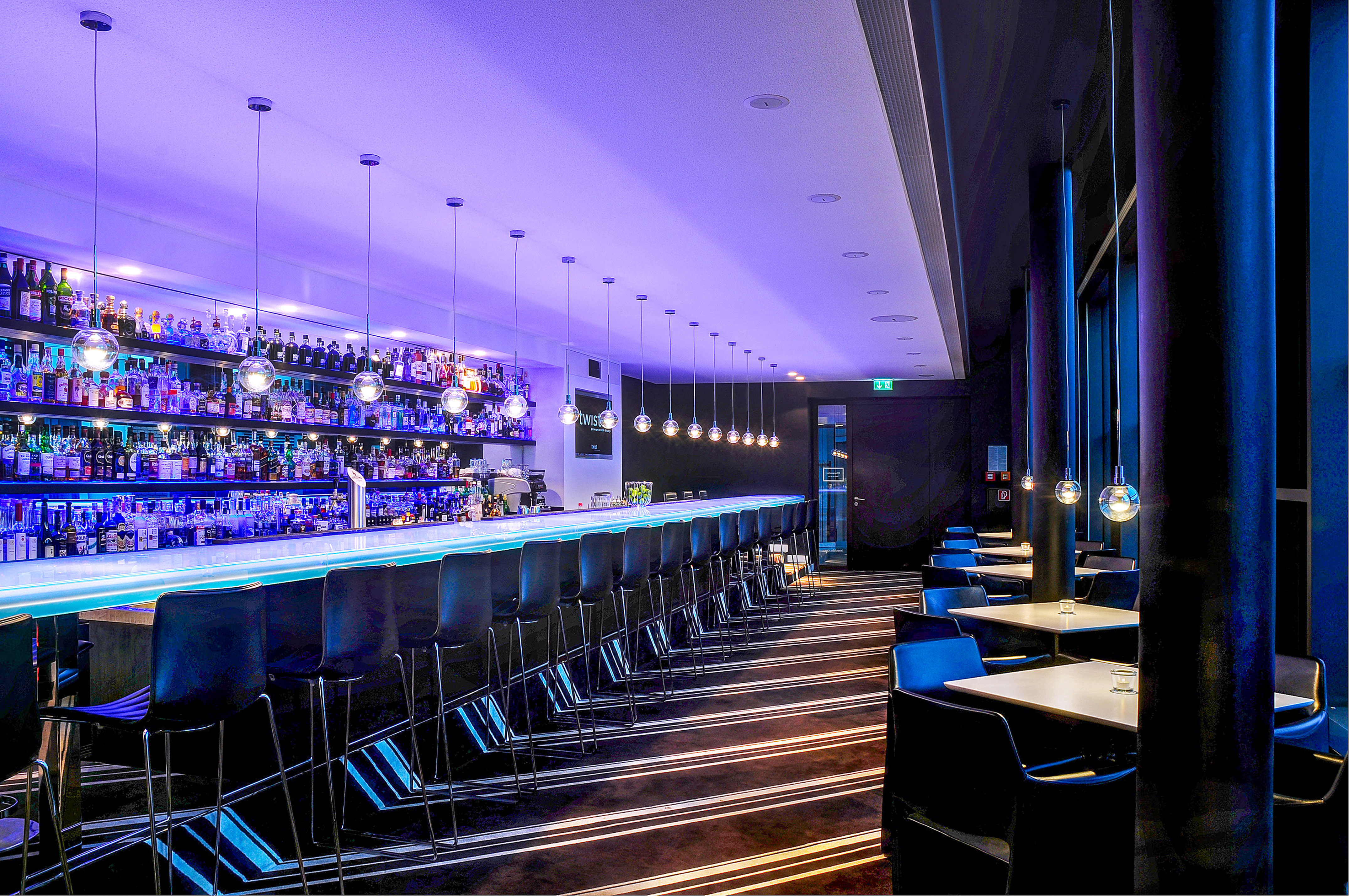 Modern bar lounge, blue lighting, long counter, liquor bottles, bar stools. - Twist Bar - Innside Dresda, Dresda