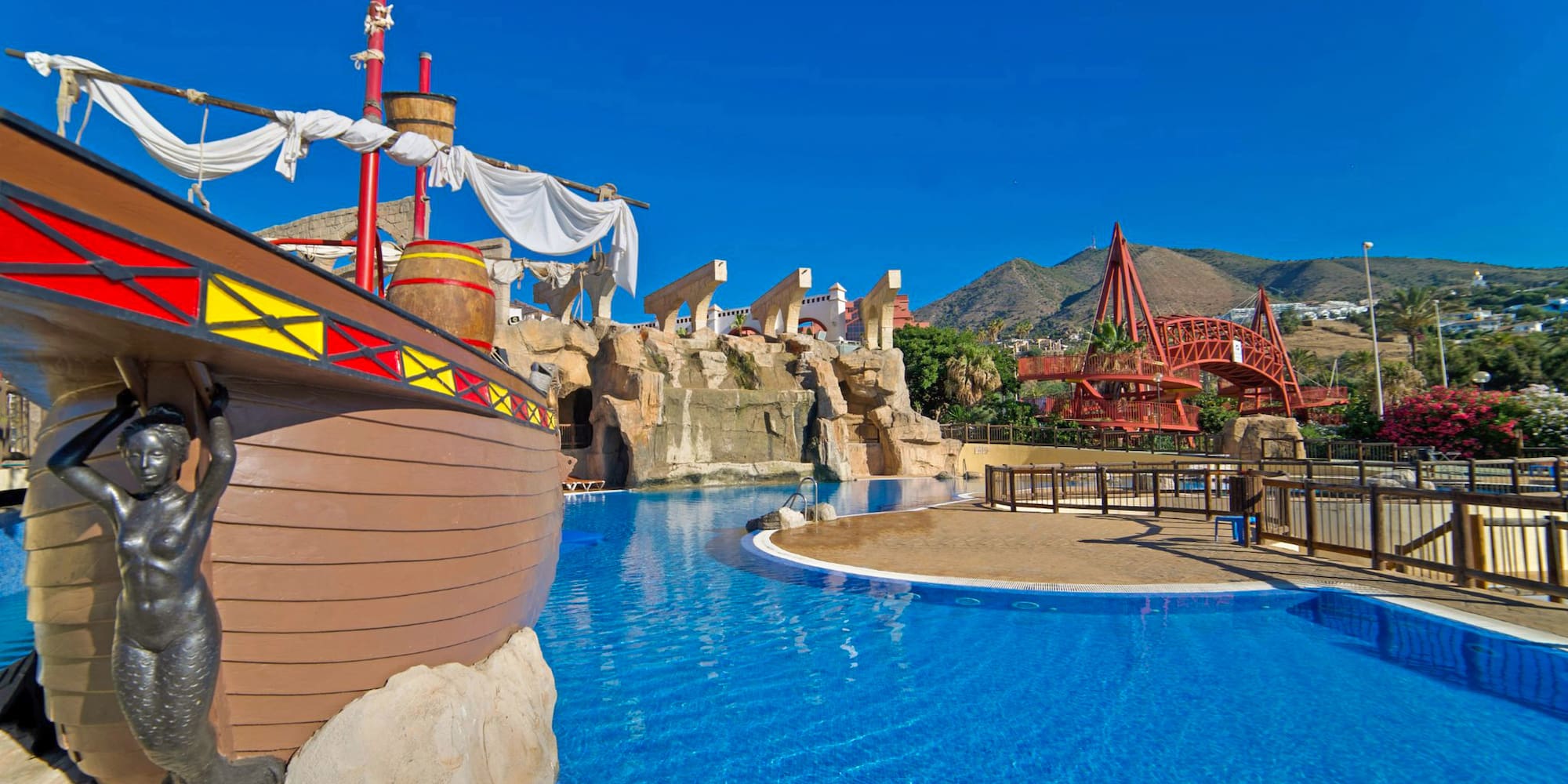 a pool with a ship and a roller coaster