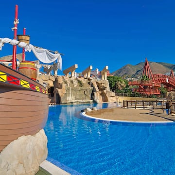a pool with a ship and a roller coaster