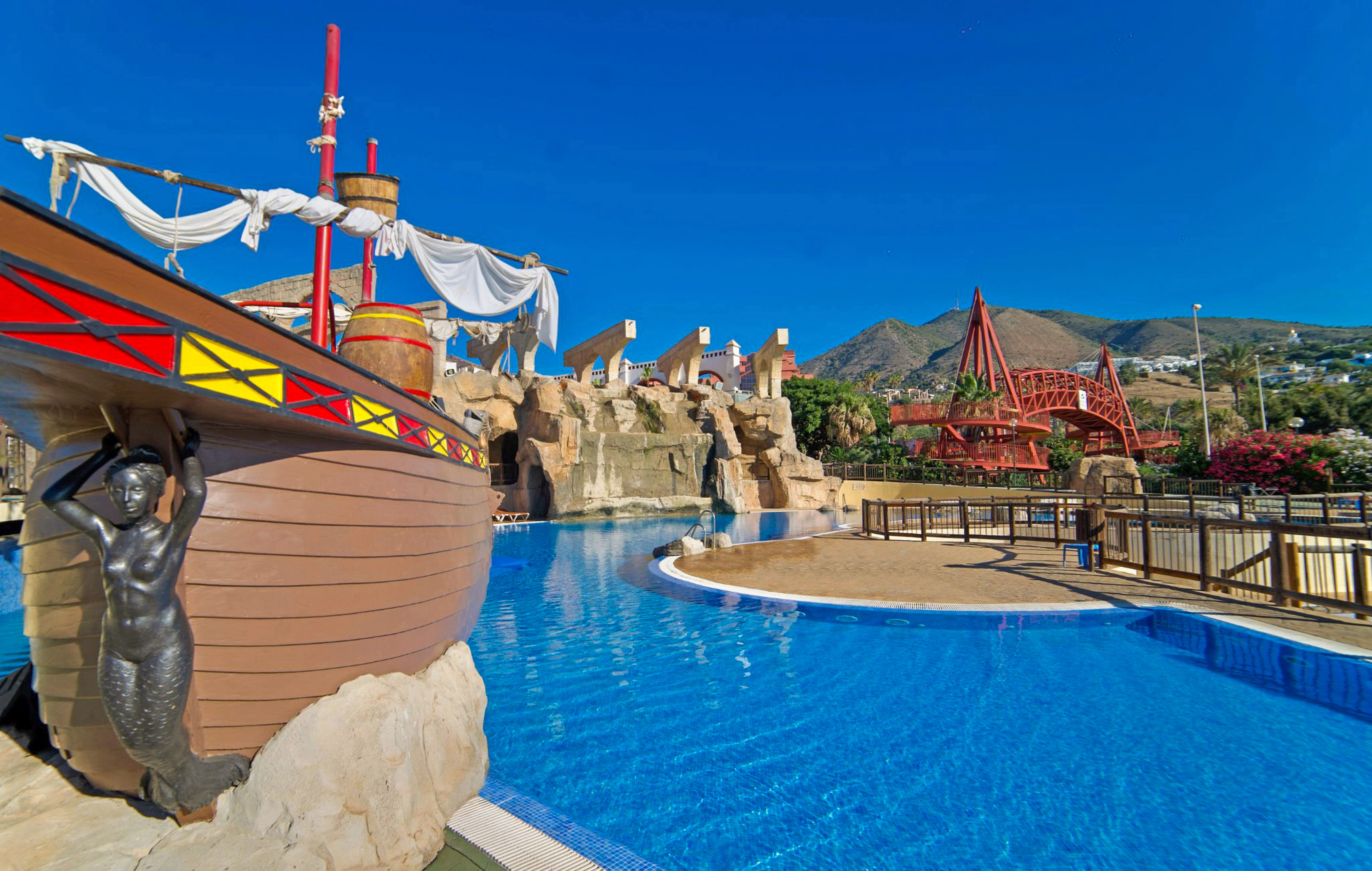 a pool with a ship and a roller coaster