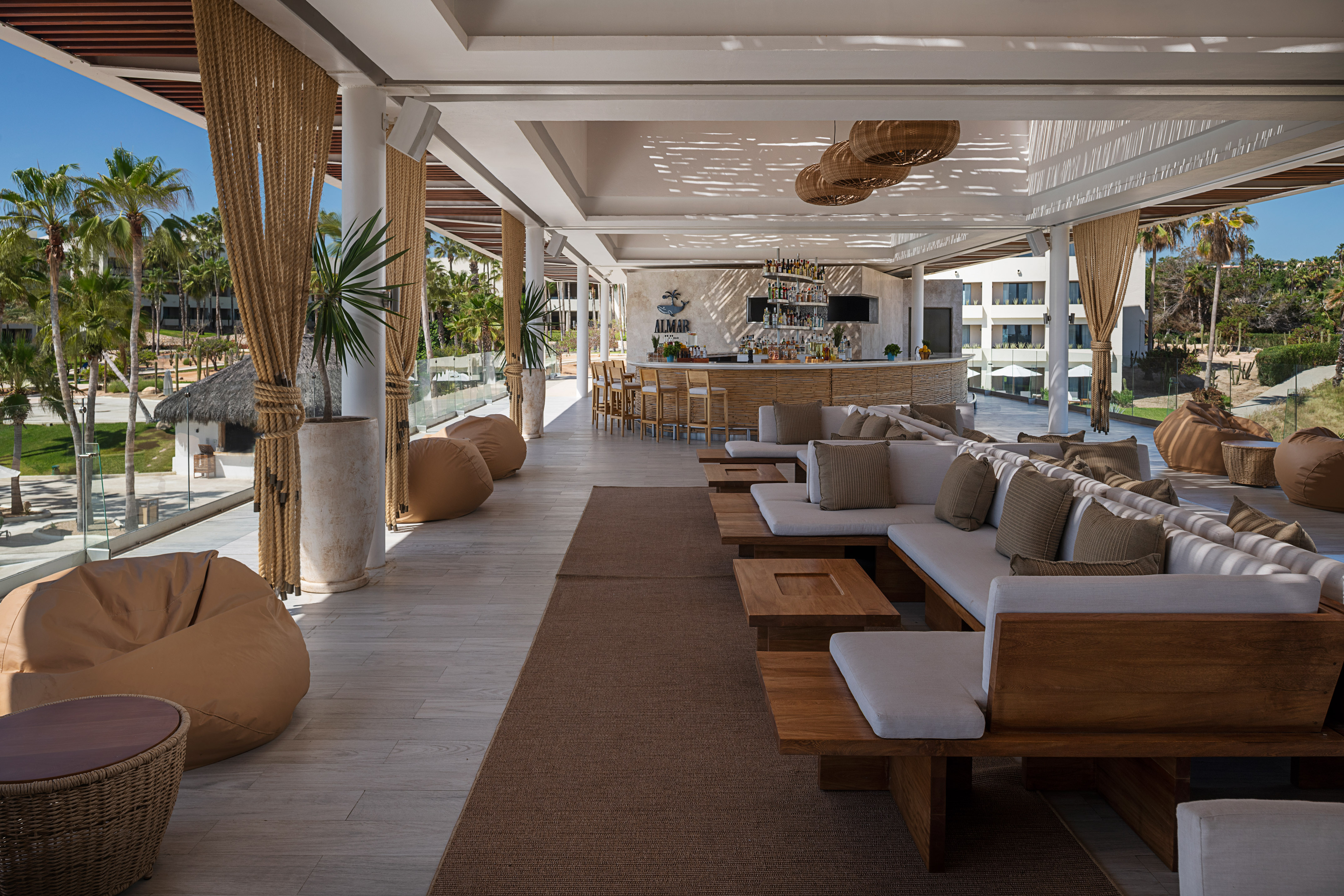 a large outdoor lounge area with a bar and chairs