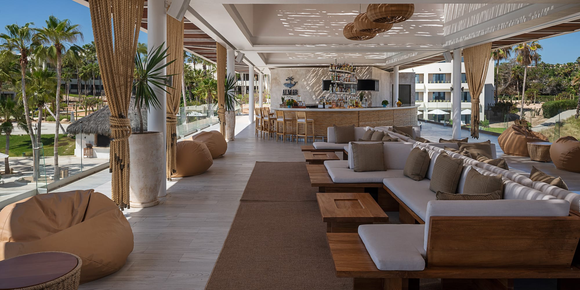 a large outdoor lounge area with a bar and chairs