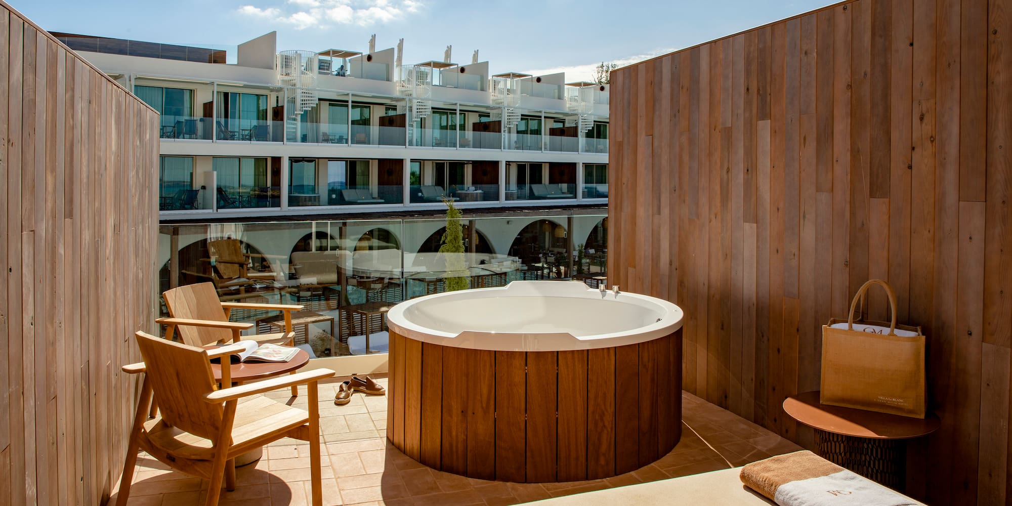 a hot tub on a patio with chairs and a table
