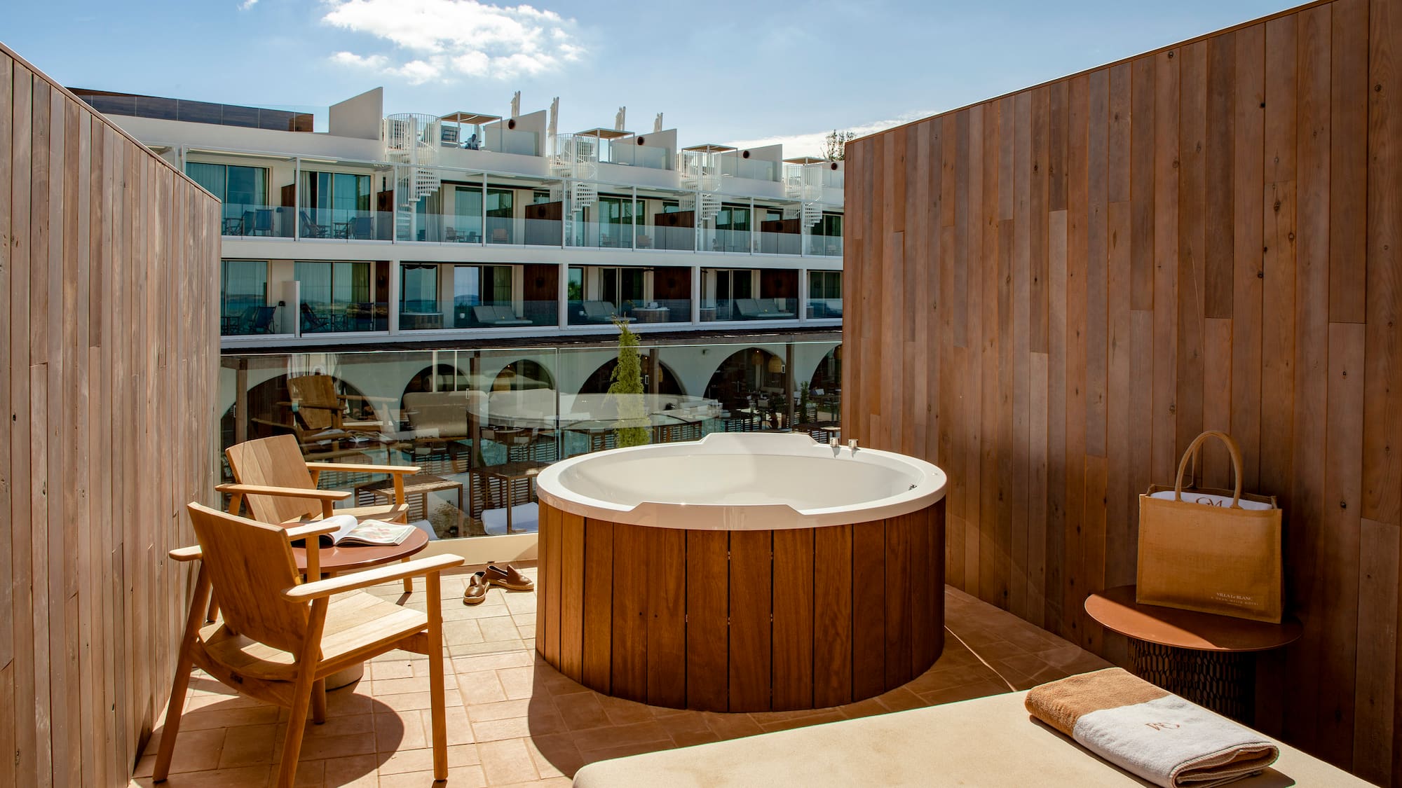 a hot tub on a patio with chairs and a table