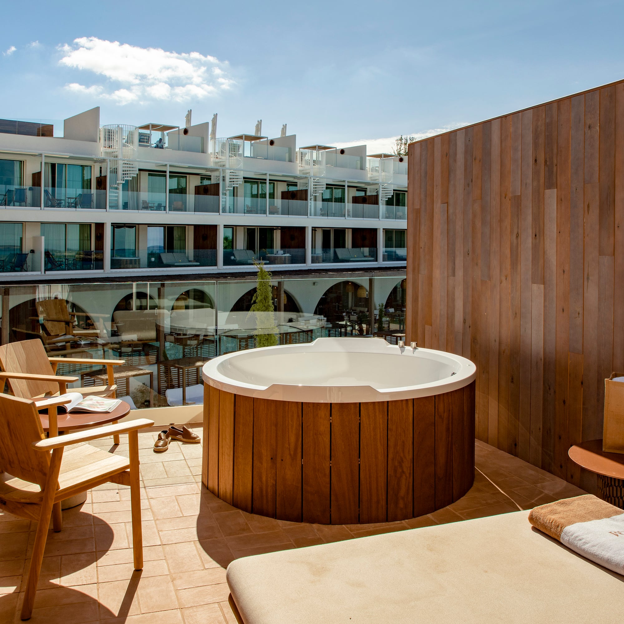 a hot tub on a patio with chairs and a table