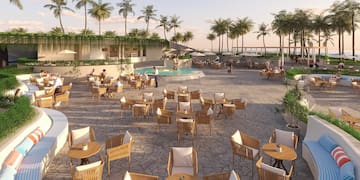 a group of people sitting at tables and chairs outside