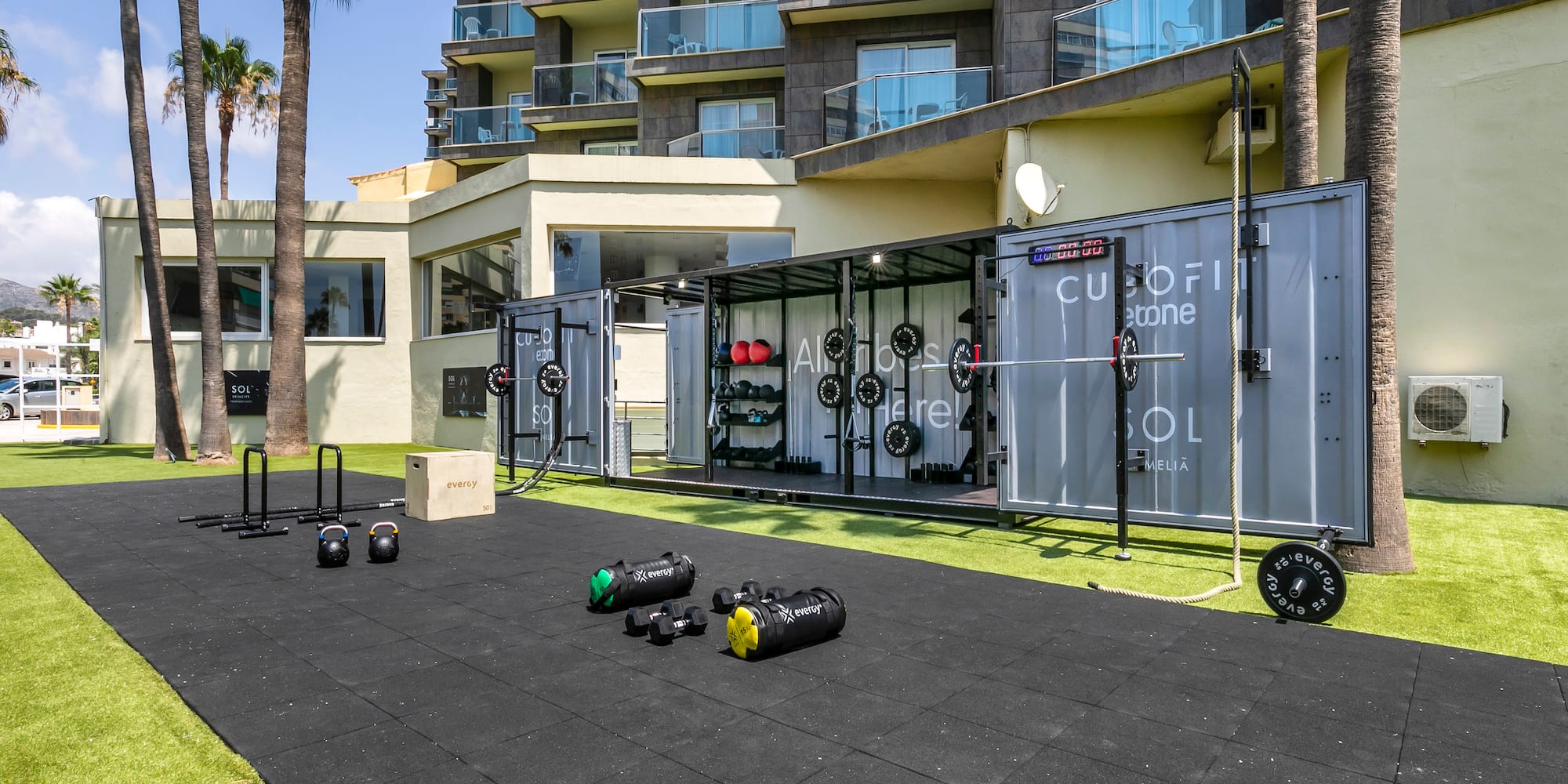 Sol Meliá outdoor Cubofit gym with fitness equipment on turf and rubber mats.