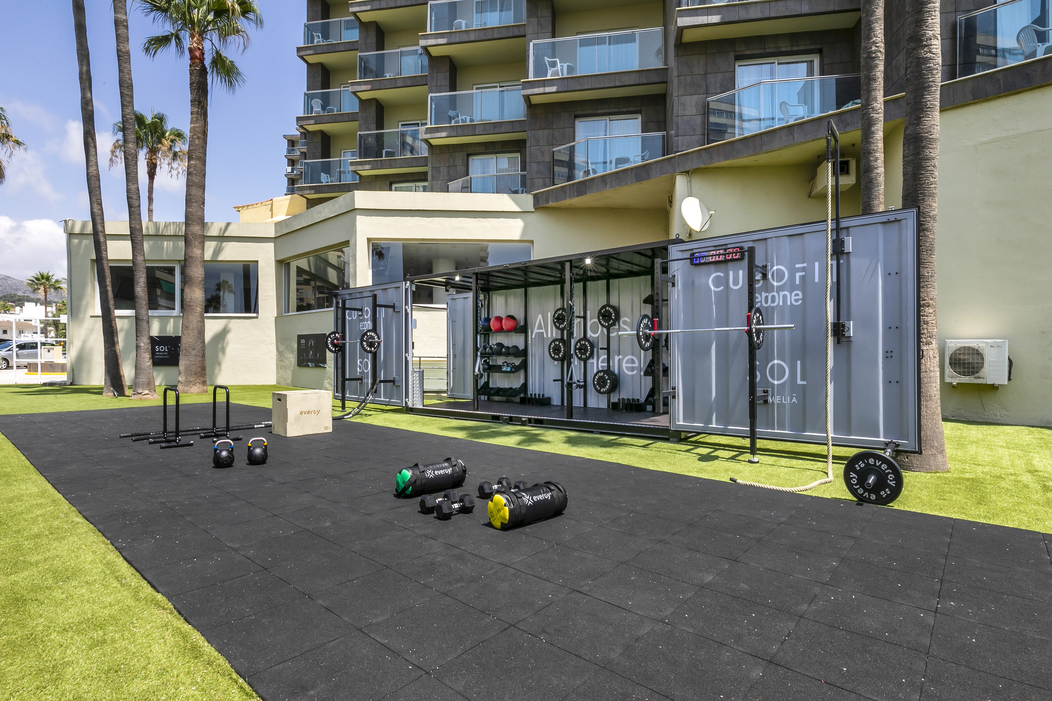 Sol Meliá outdoor Cubofit gym with fitness equipment on turf and rubber mats.