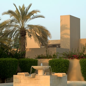 a fountain in a courtyard with palm trees