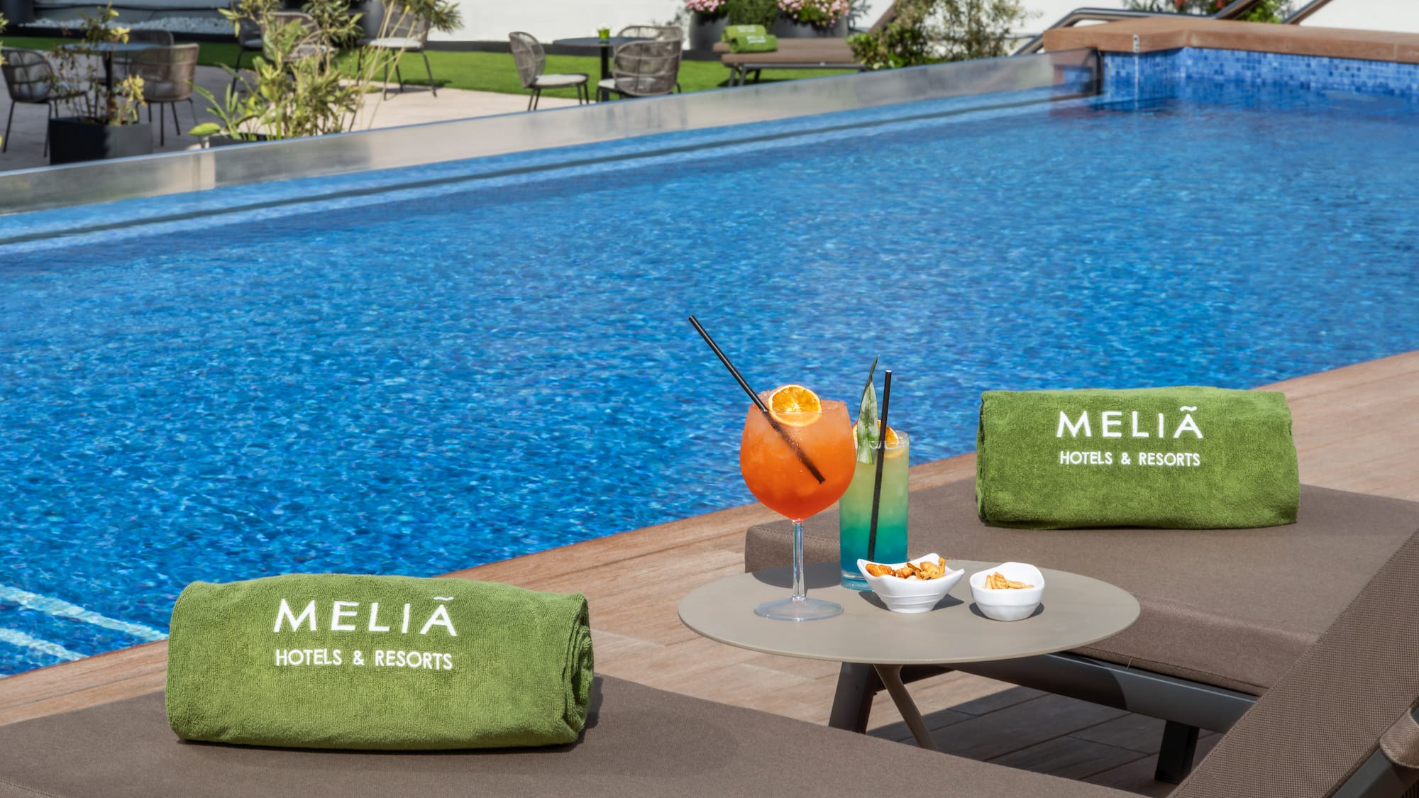 a pool with a drink and towels