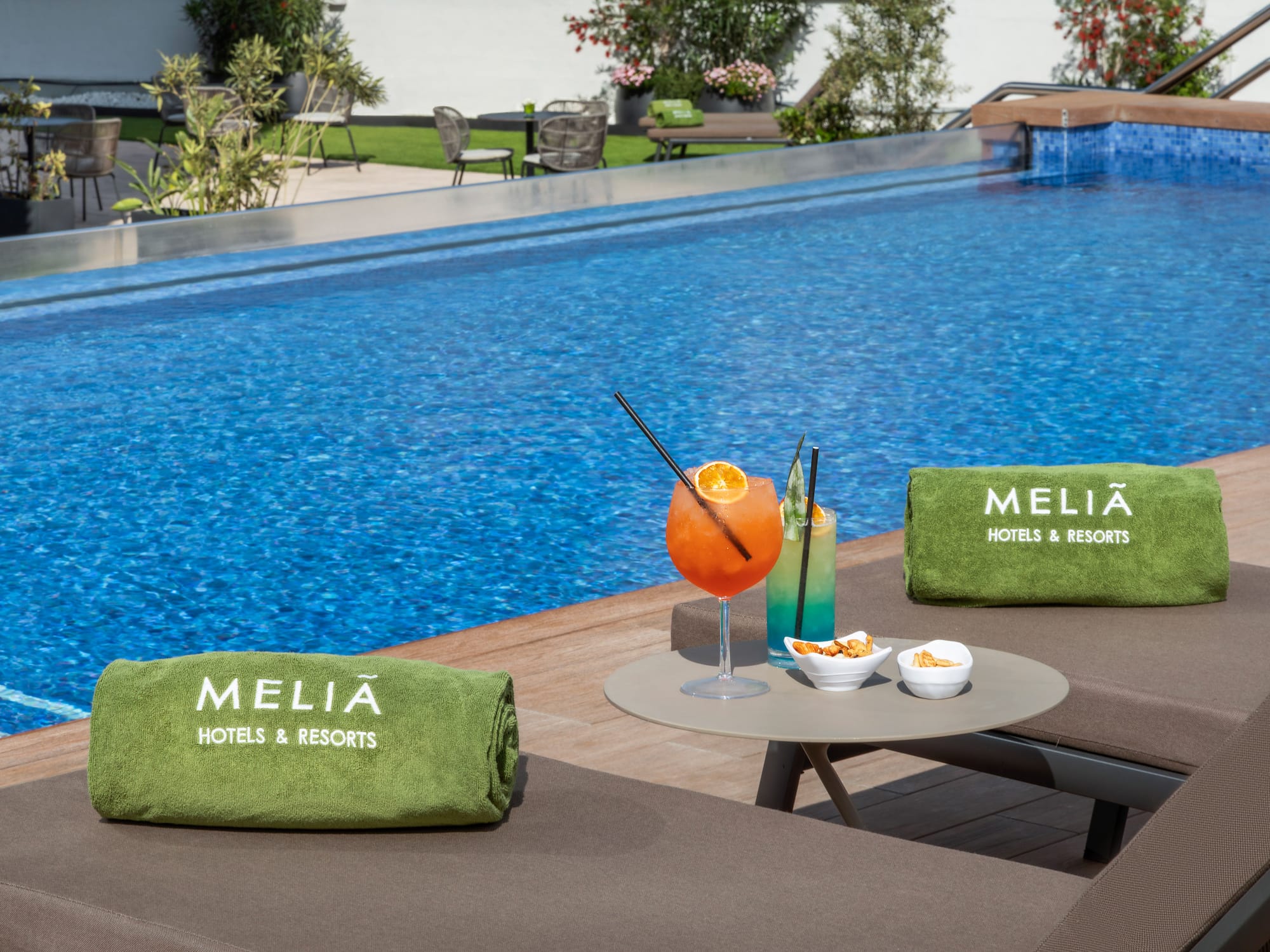 Meliã resort pool deck with lounge chairs, cocktails, and snacks.