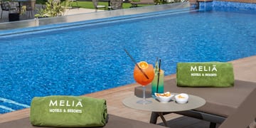 a pool with a drink and towels