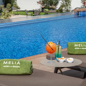 a pool with a drink and towels