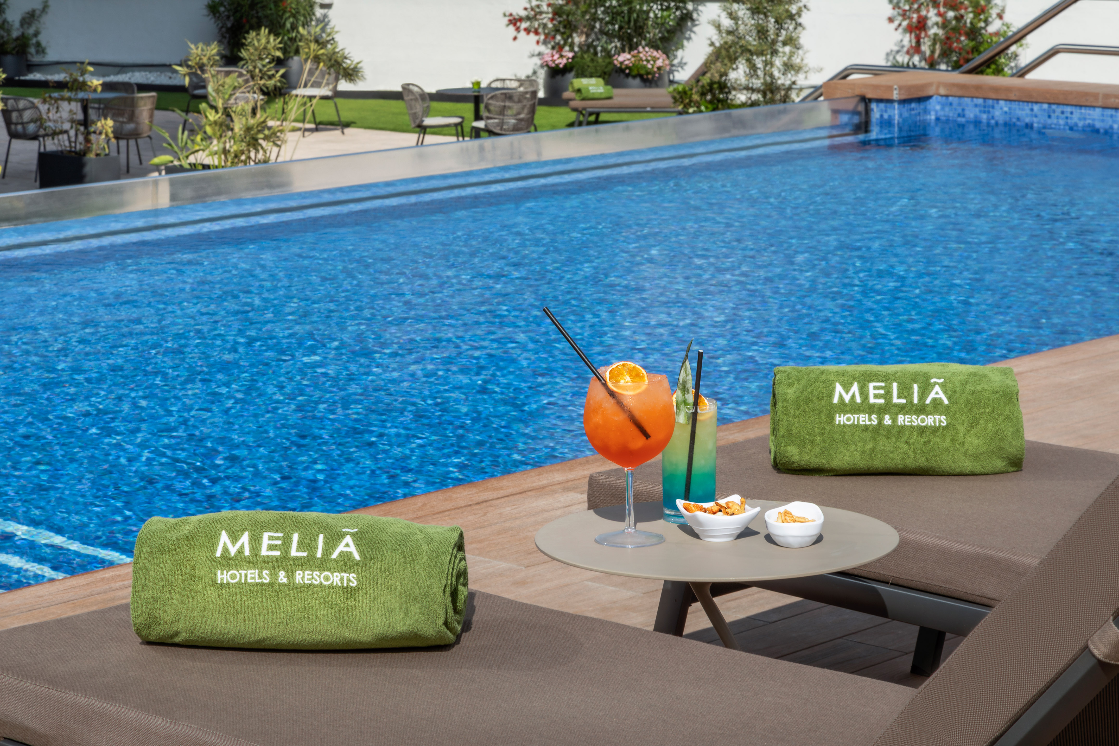 Meliã resort pool deck with lounge chairs, cocktails, and snacks.