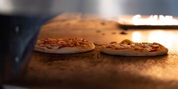 a couple of pizzas on a counter