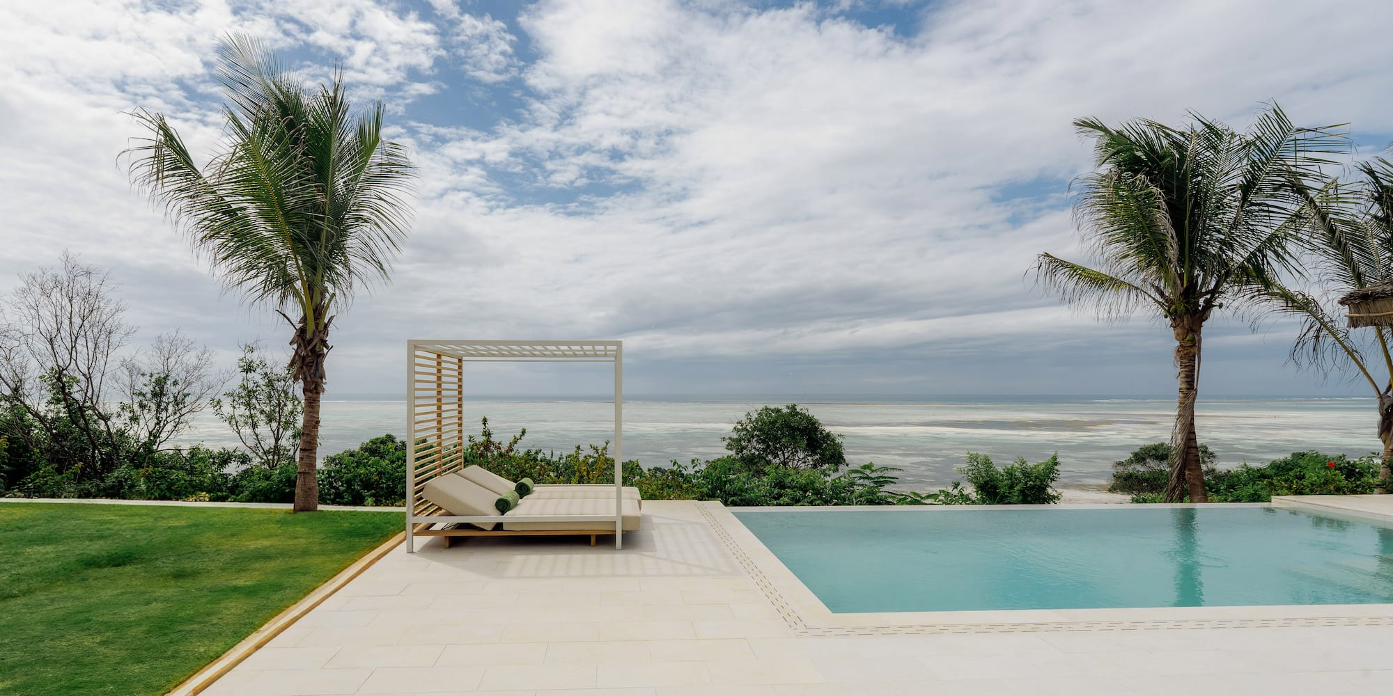 a pool with a lounge chair and palm trees