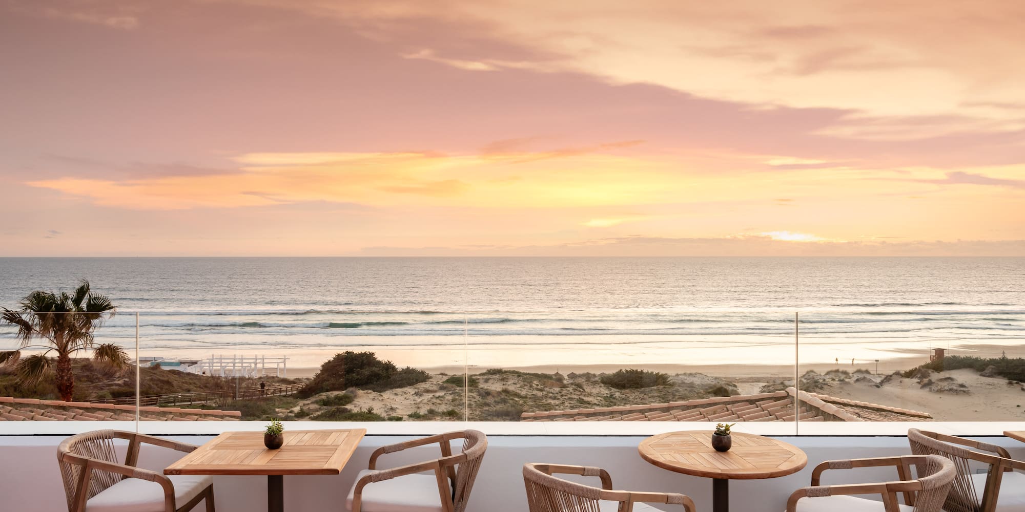 a table and chairs on a patio overlooking a beach