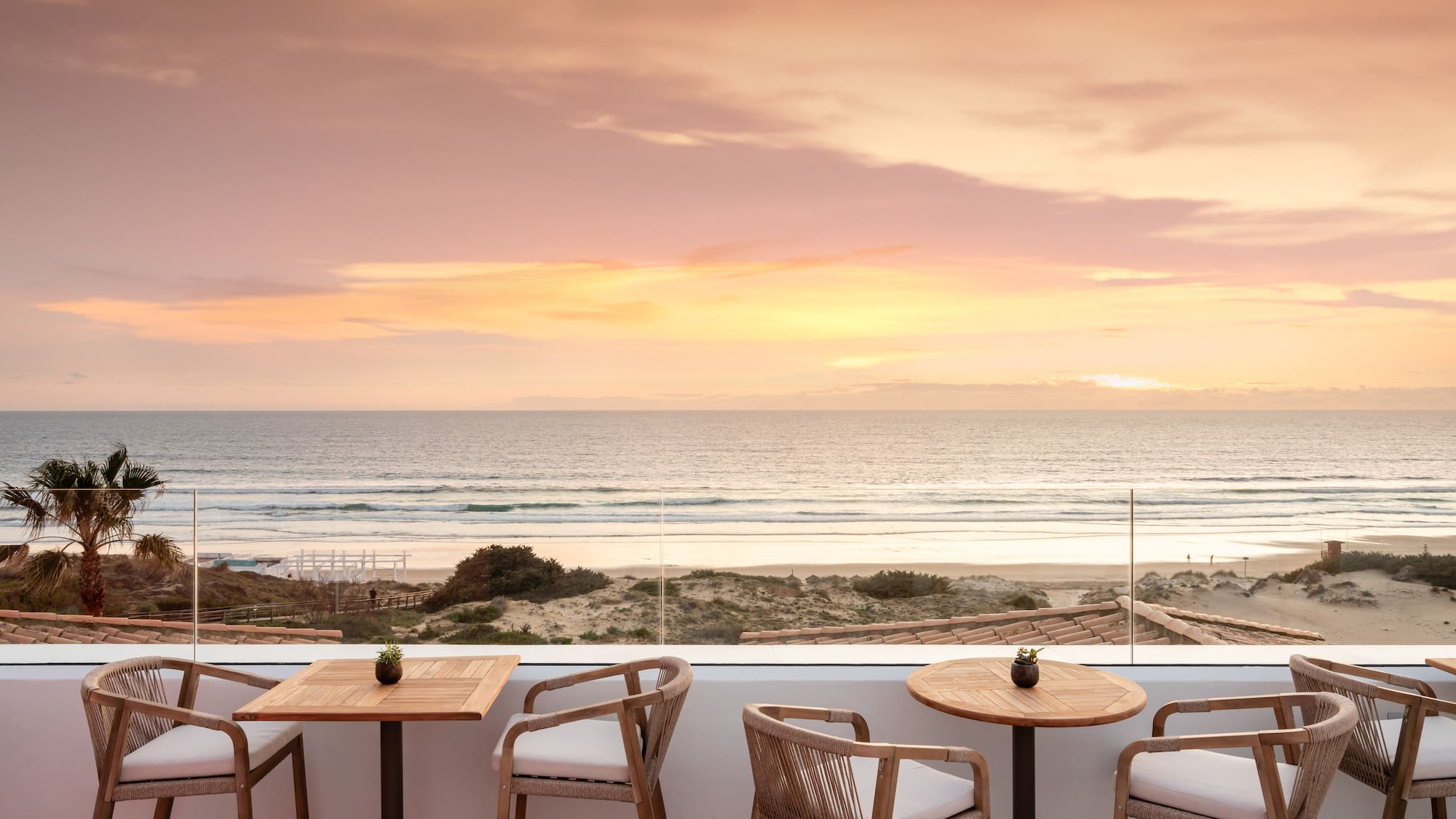 a table and chairs on a patio overlooking a beach