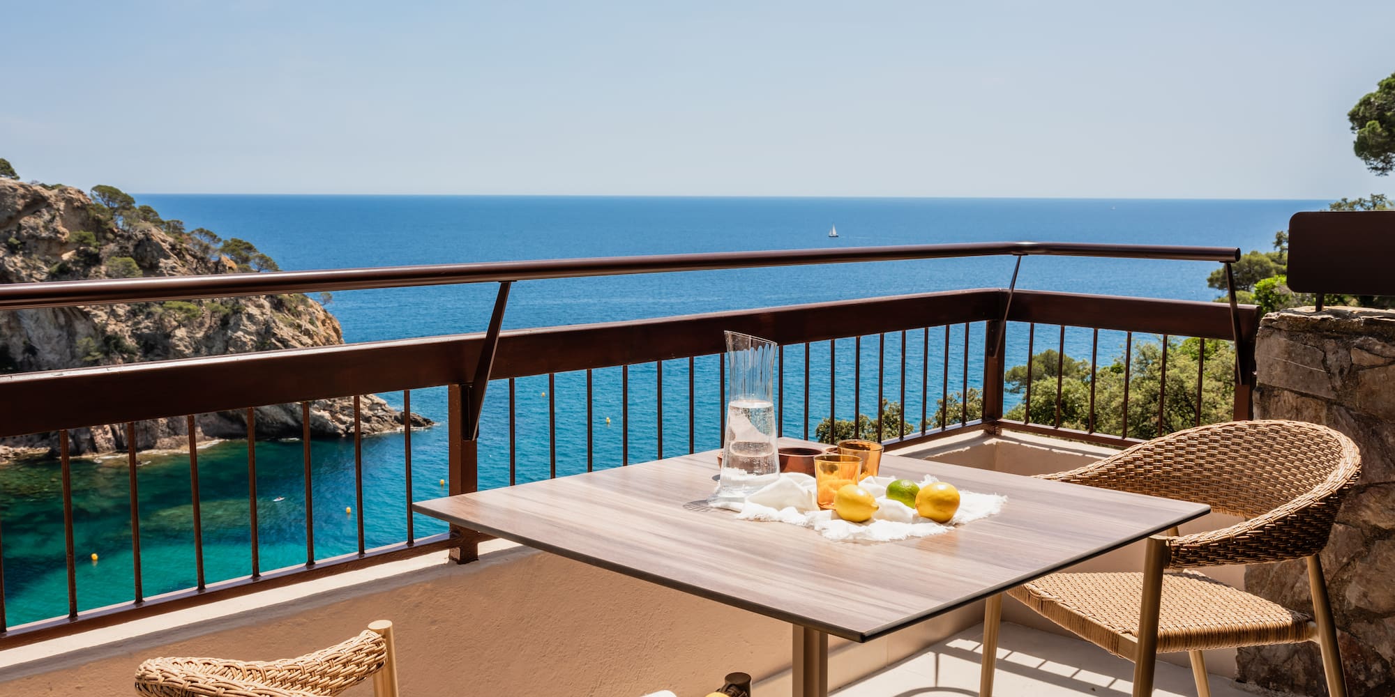 a table and chairs on a balcony overlooking the ocean