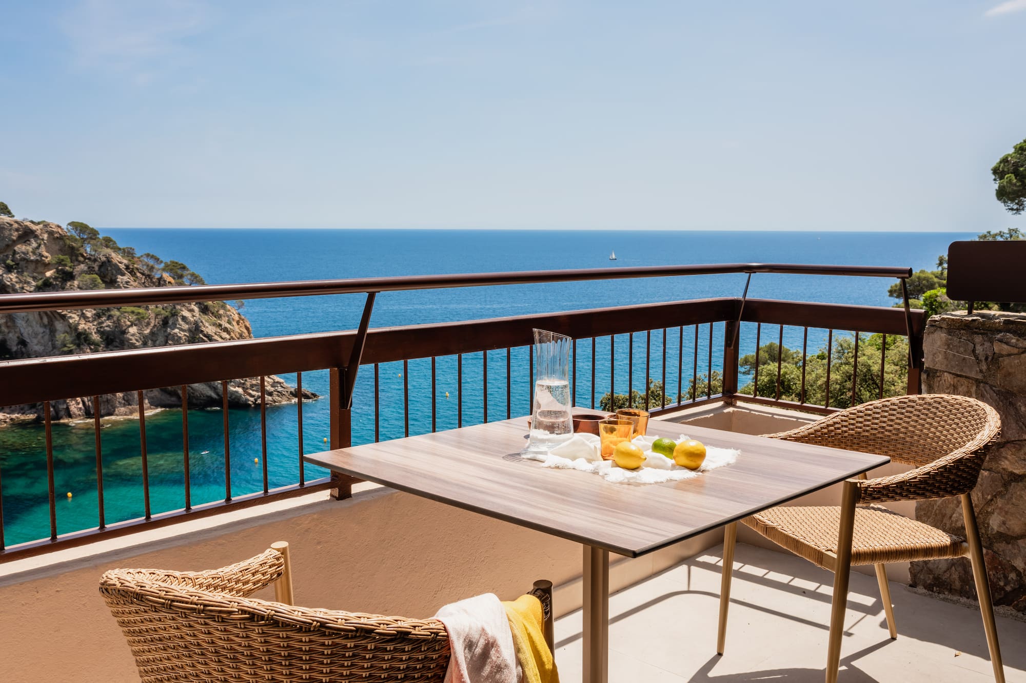 a table and chairs on a balcony overlooking the ocean
