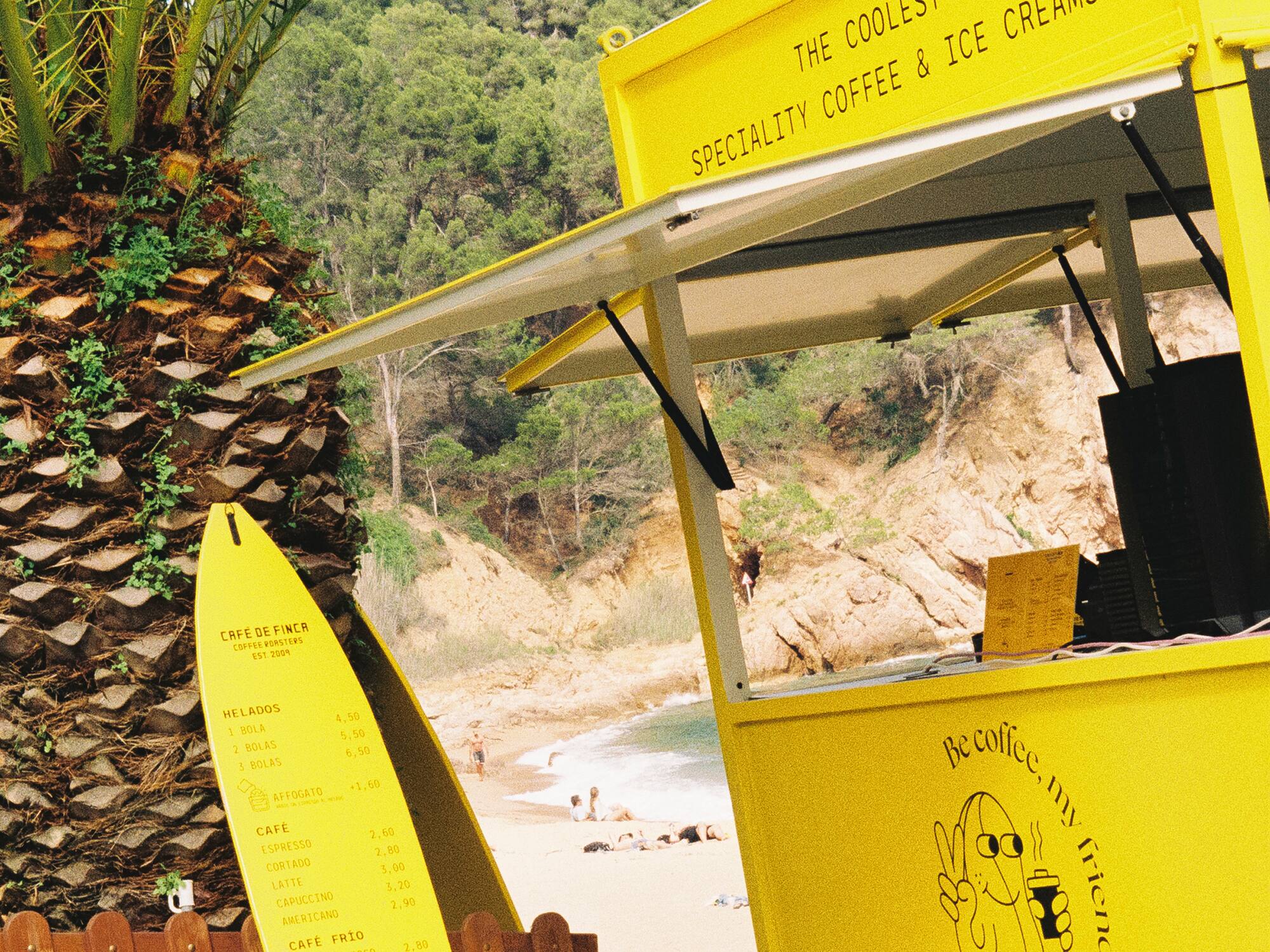 a yellow stand with a surfboard next to a palm tree