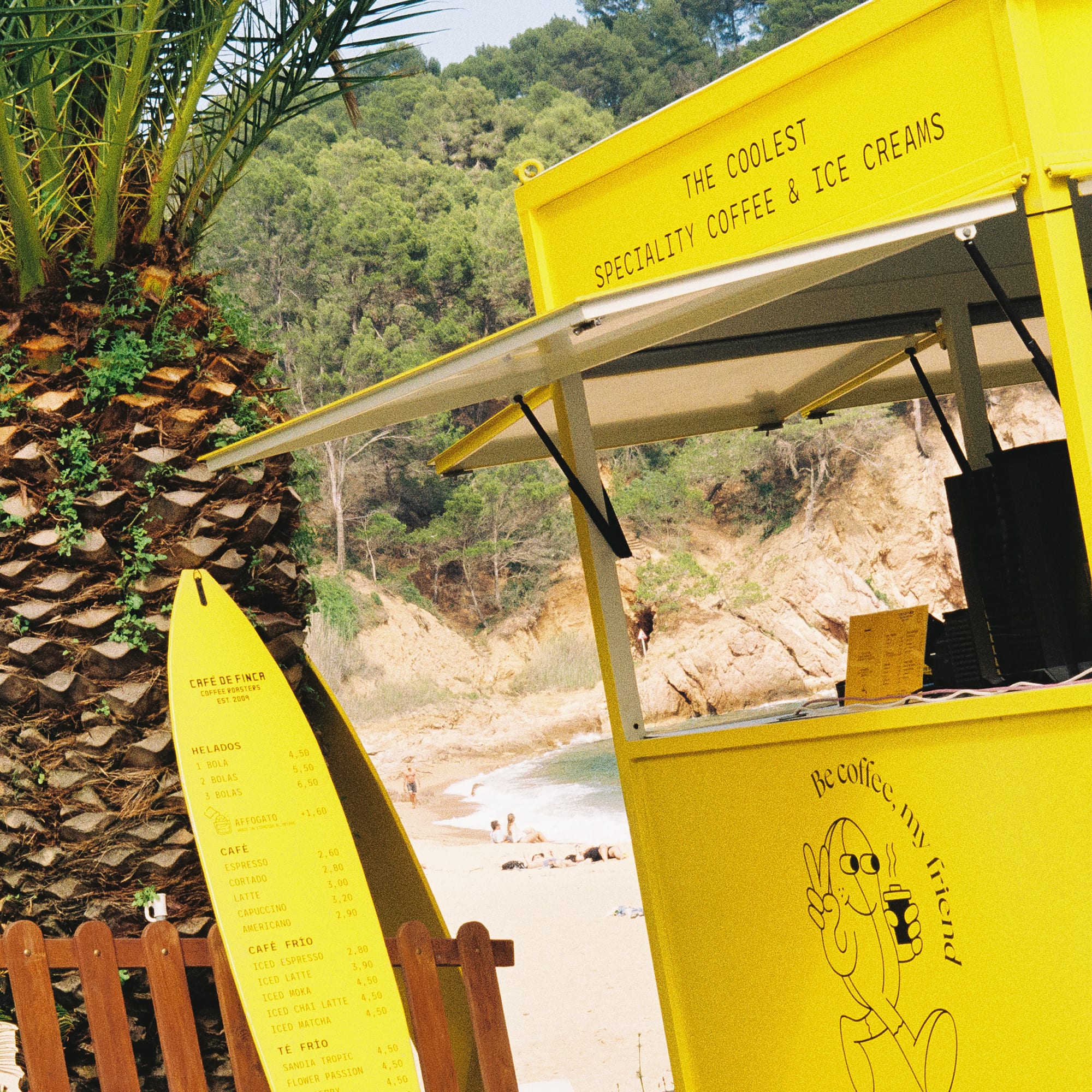 a yellow stand with a surfboard next to a palm tree