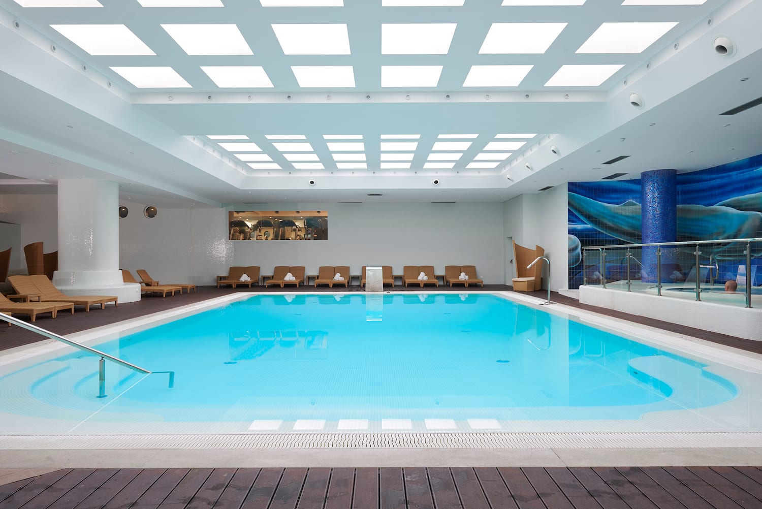 a swimming pool with chairs and a deck.