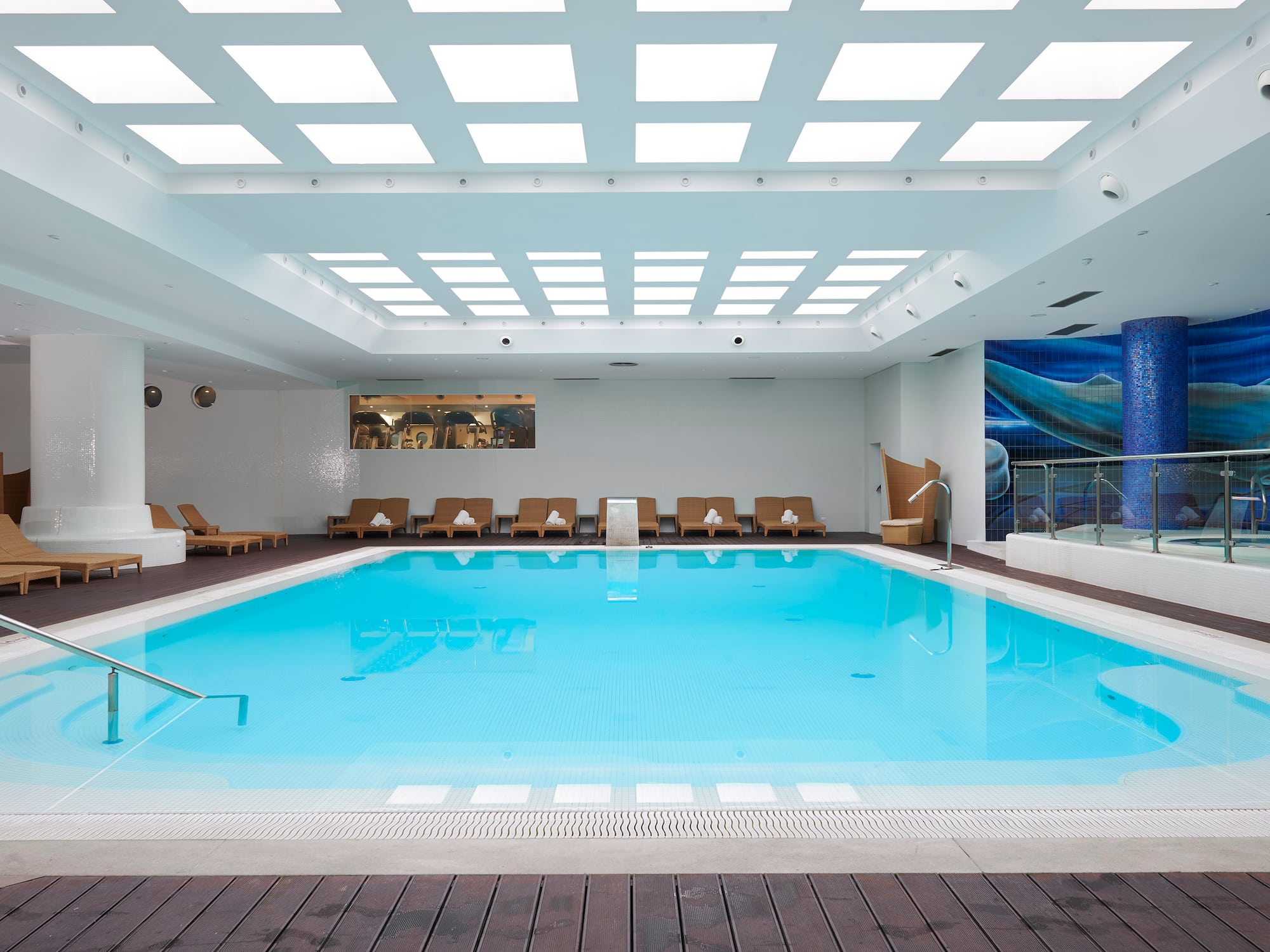 a swimming pool with chairs and a deck.