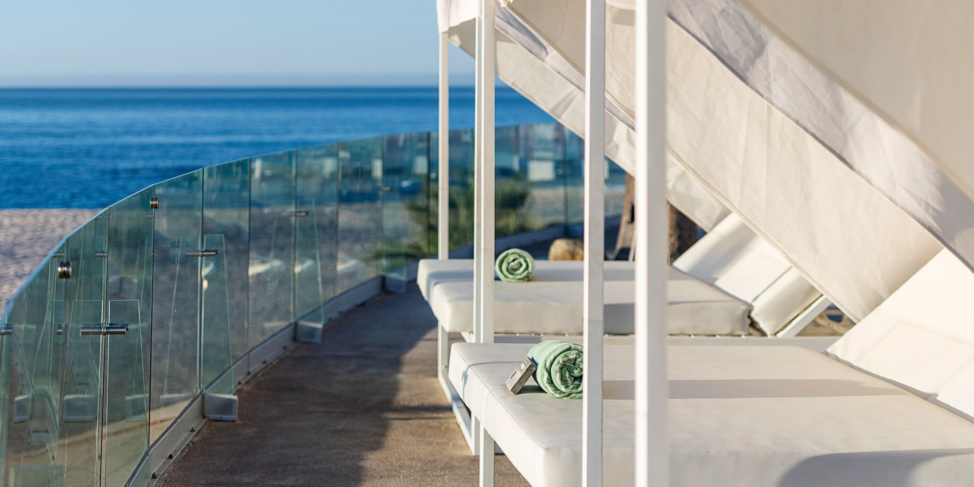 a white beds on a deck overlooking the ocean