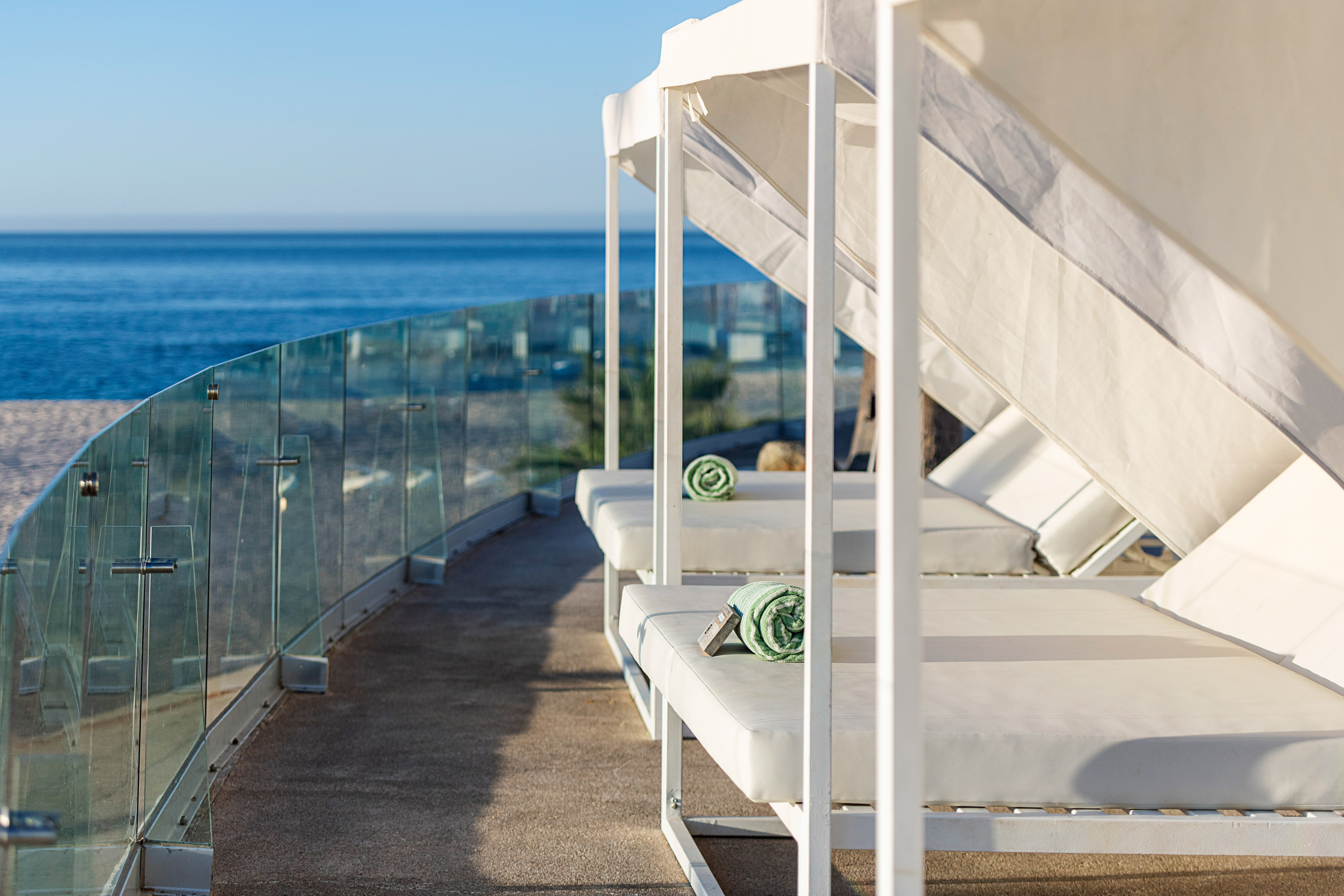 a white beds on a deck overlooking the ocean