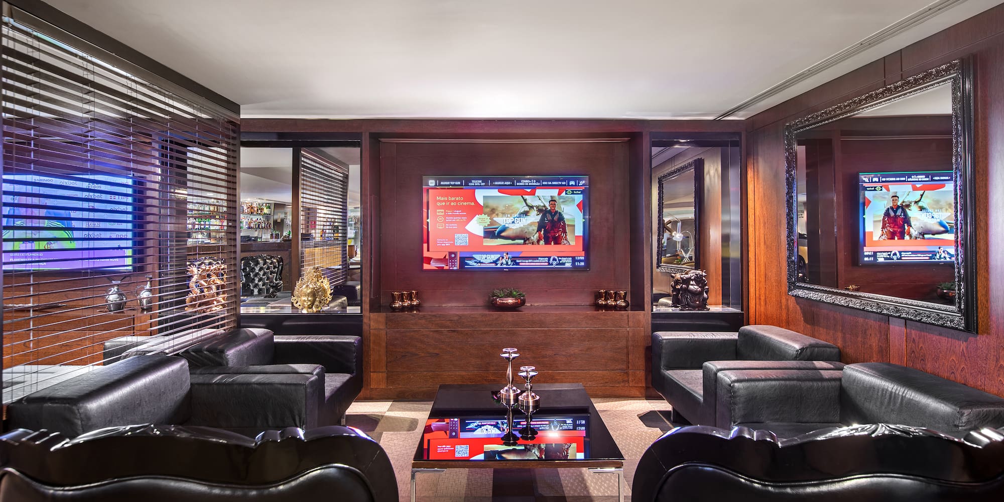 a room with black leather chairs and a tv on the wall