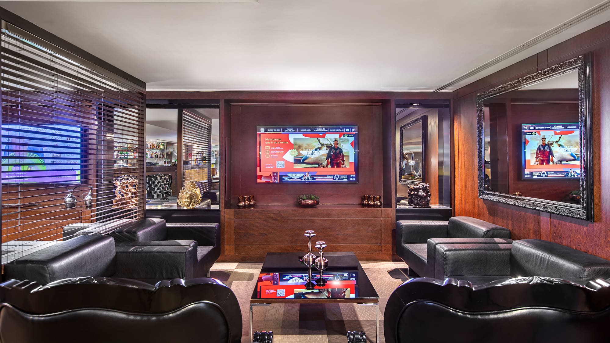a room with black leather chairs and a tv on the wall
