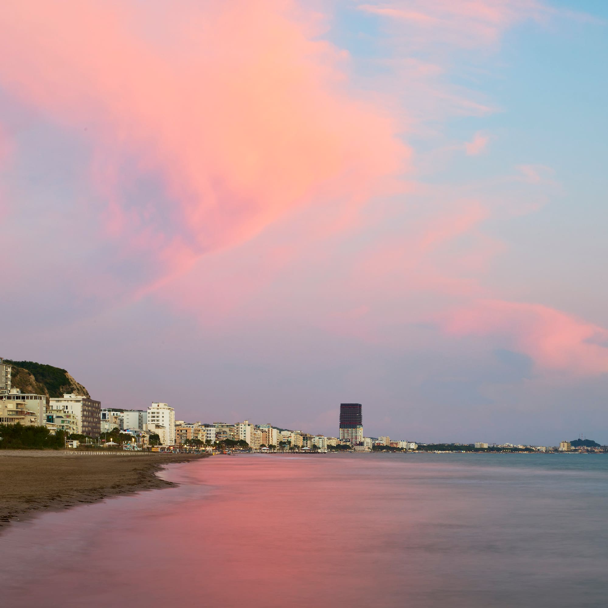 a beach with buildings and water