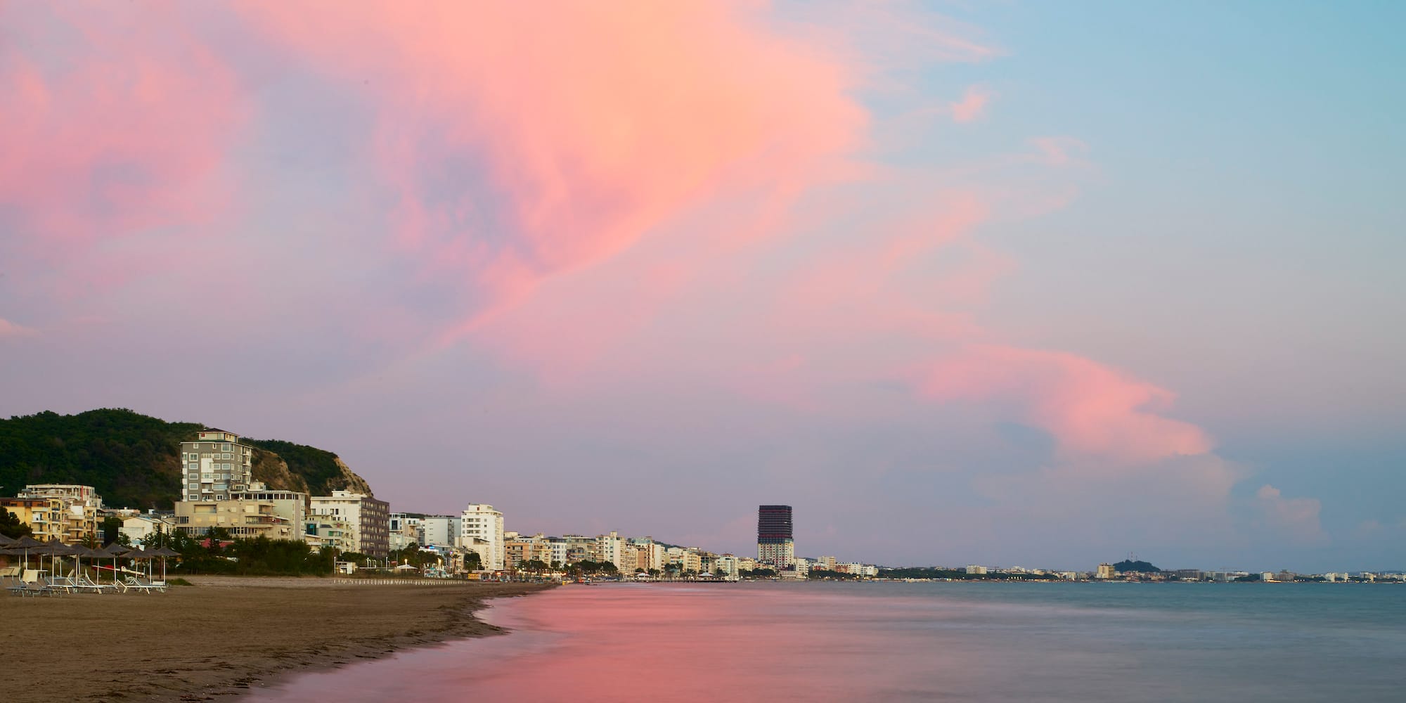 a beach with buildings and water