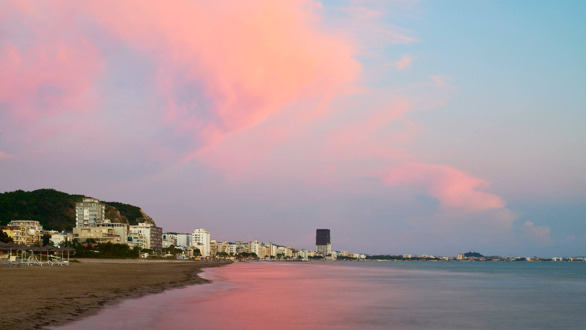 a beach with buildings and water