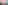 Pink sunset over coastal city beach skyline with tranquil sea reflections.