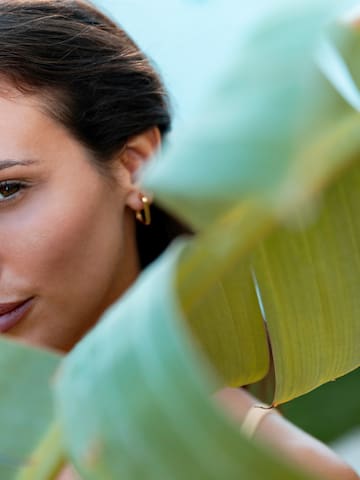 a woman with dark hair and a leaf