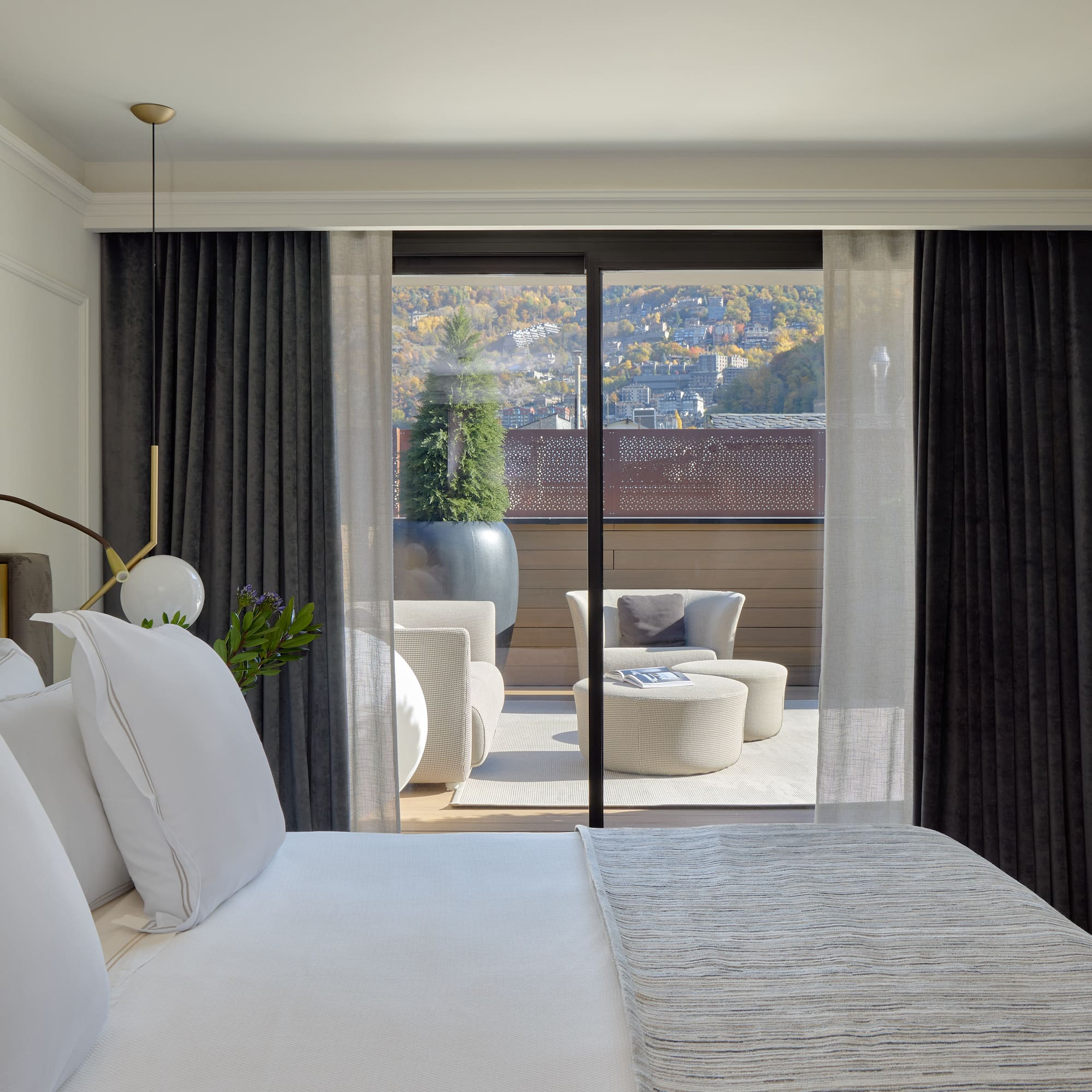 a bed with white pillows and a glass door