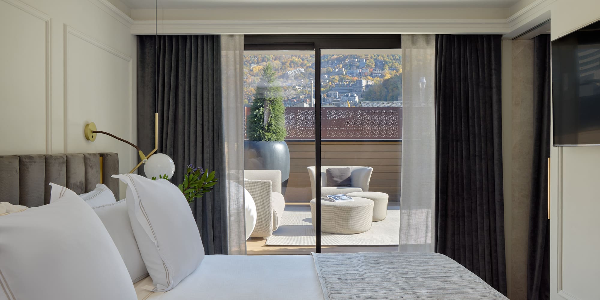 a bed with white pillows and a glass door