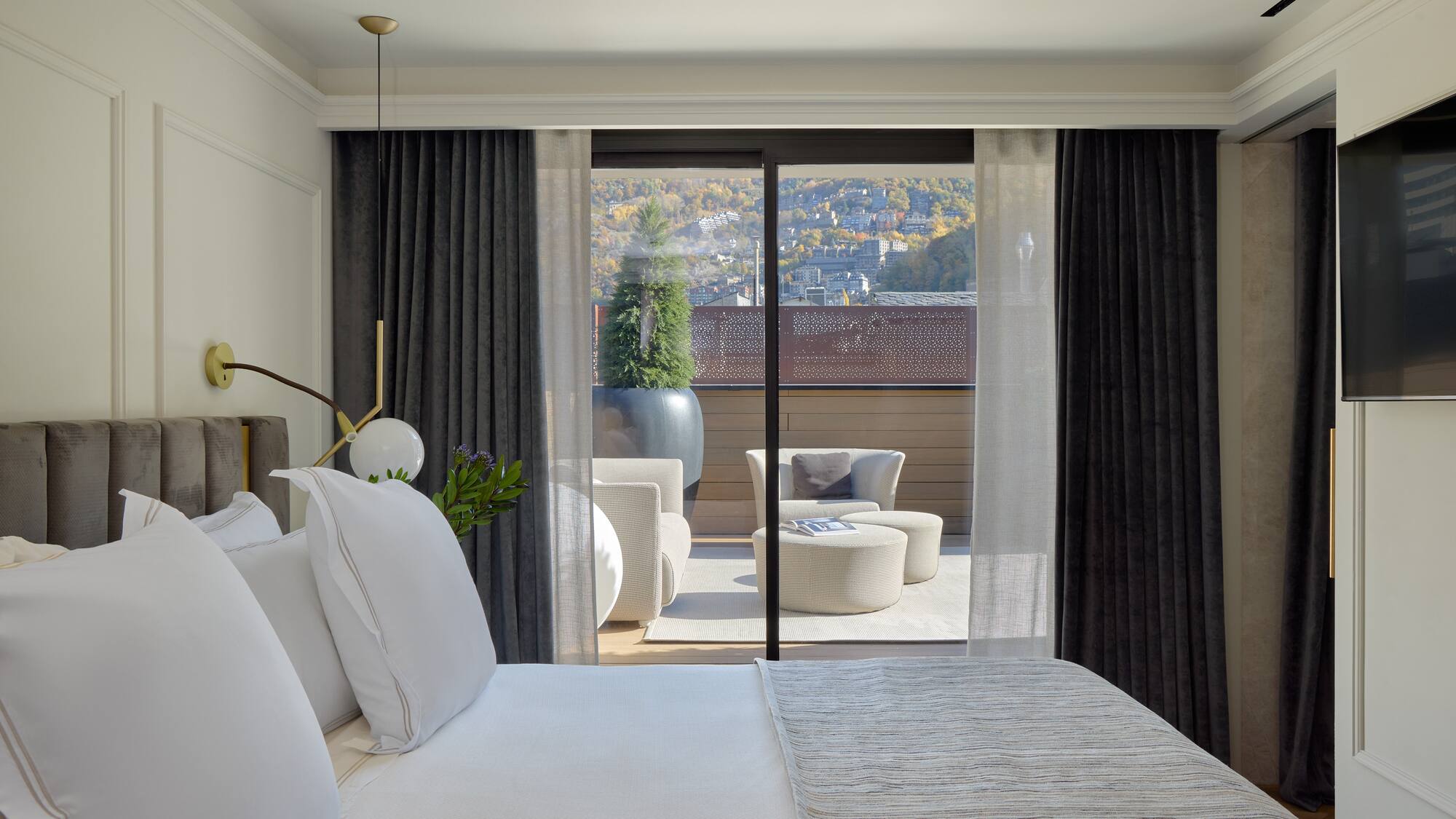 a bed with white pillows and a glass door