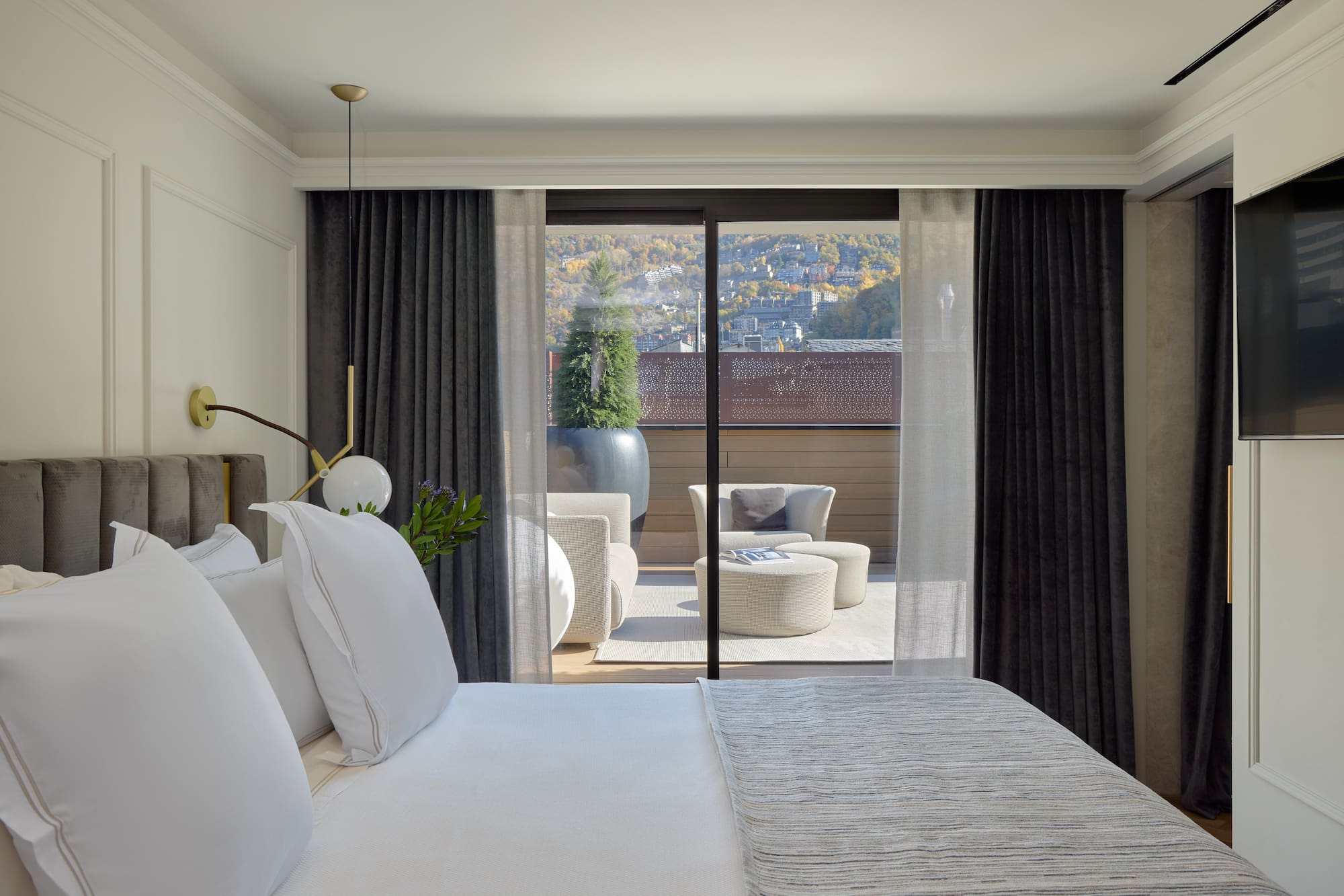 a bed with white pillows and a glass door