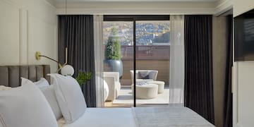 a bed with white pillows and a glass door