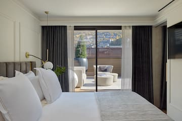 a bed with white pillows and a glass door