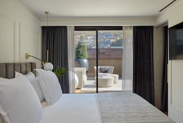 a bed with white pillows and a glass door
