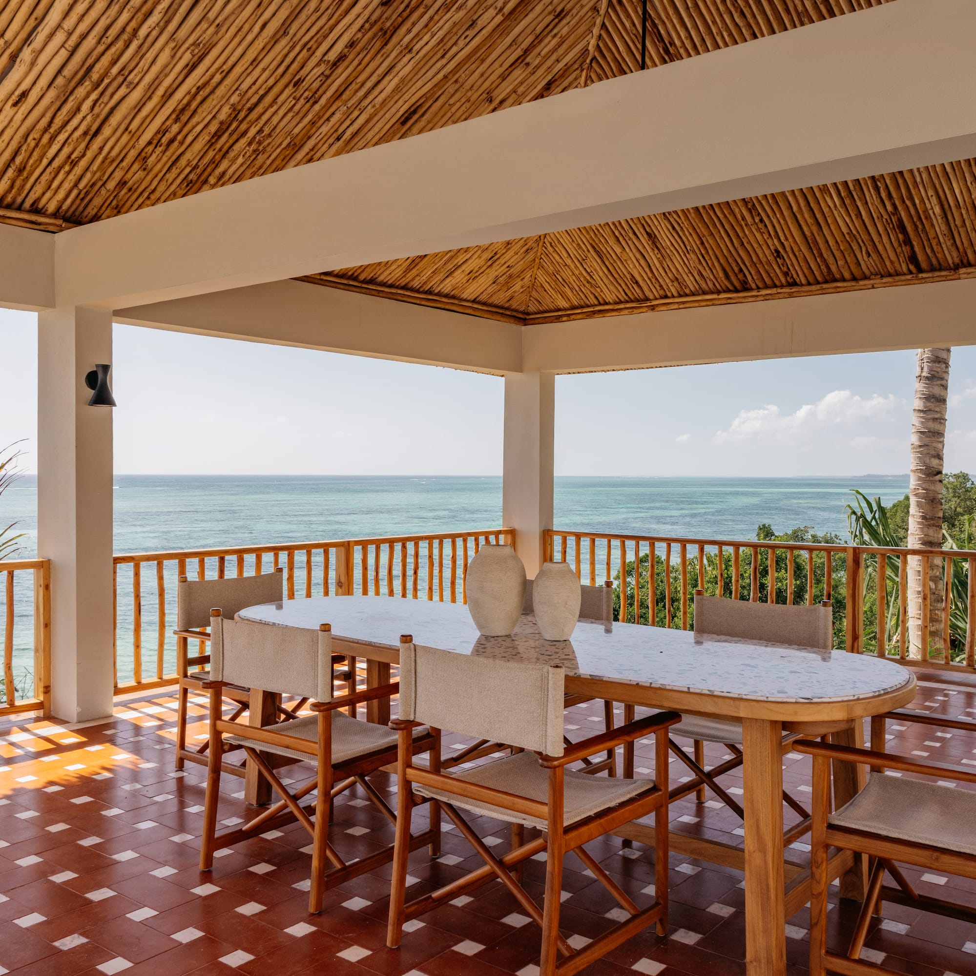 a table and chairs on a deck overlooking the ocean