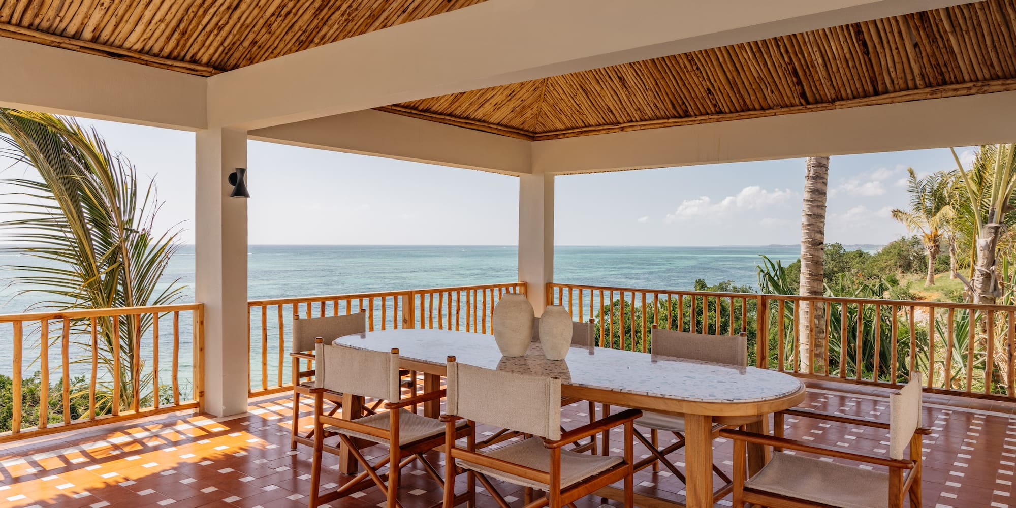a table and chairs on a deck overlooking the ocean
