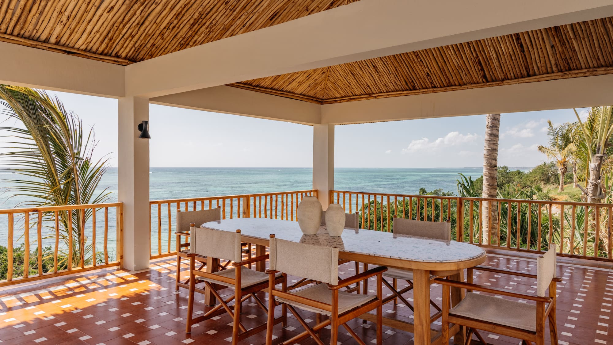 a table and chairs on a deck overlooking the ocean