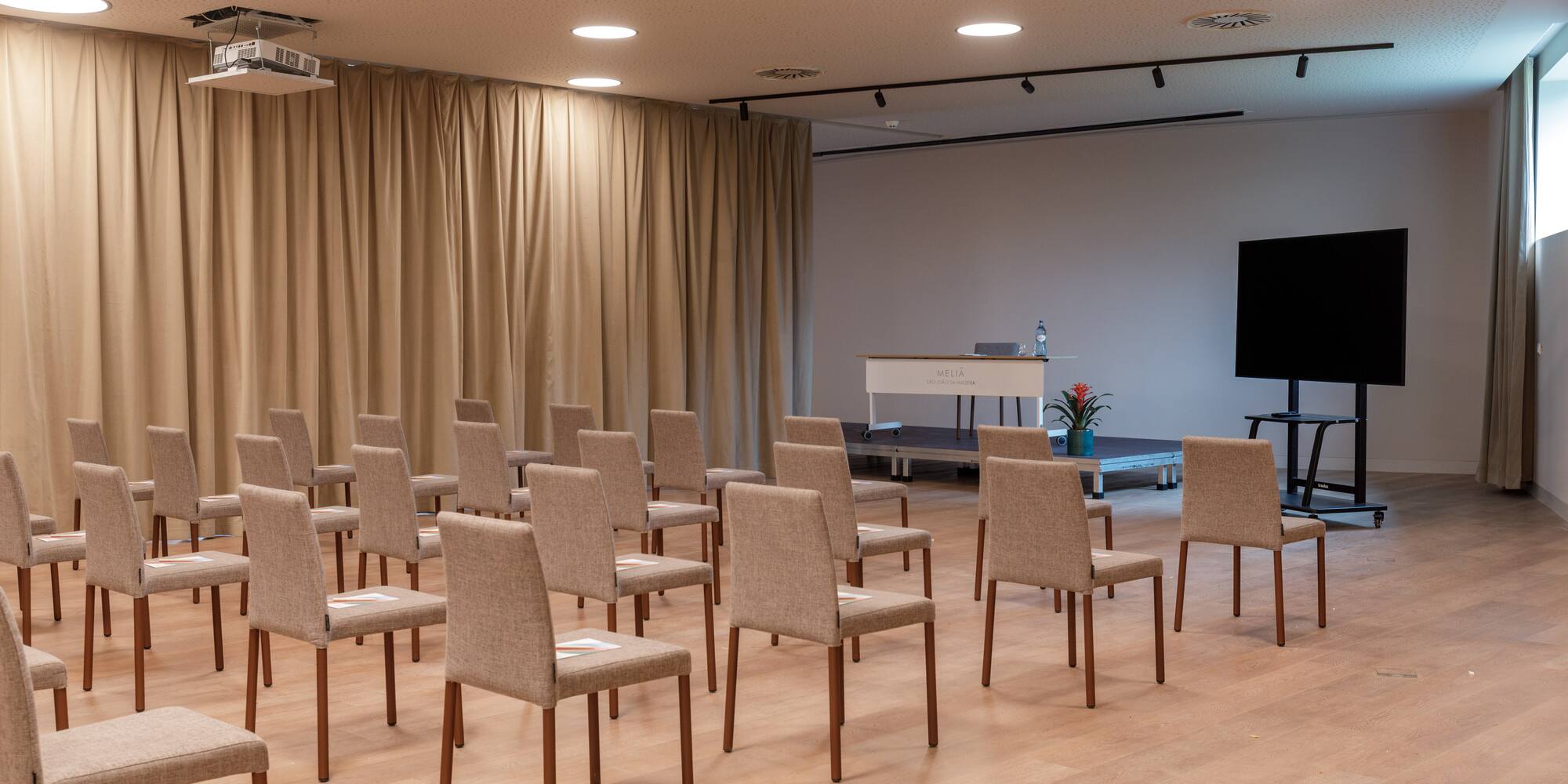 a room with chairs and a screen