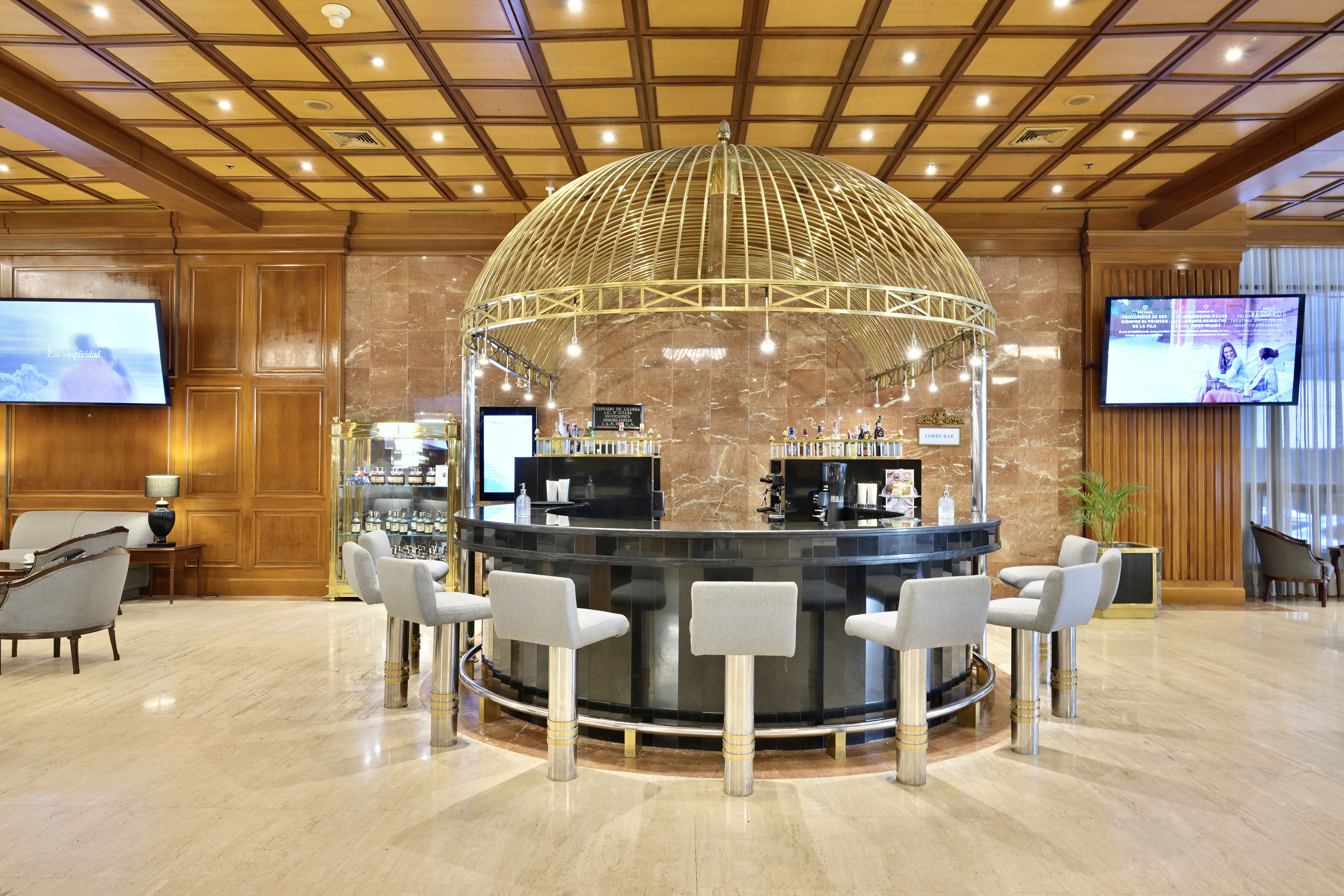 Luxury hotel lobby bar featuring a golden domed canopy and modern seating.