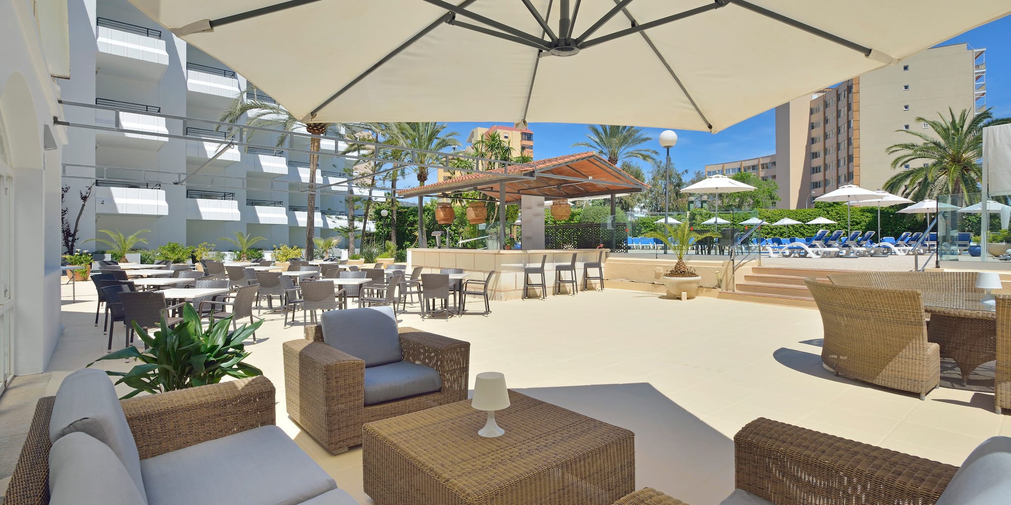 a patio area with chairs and tables and umbrellas